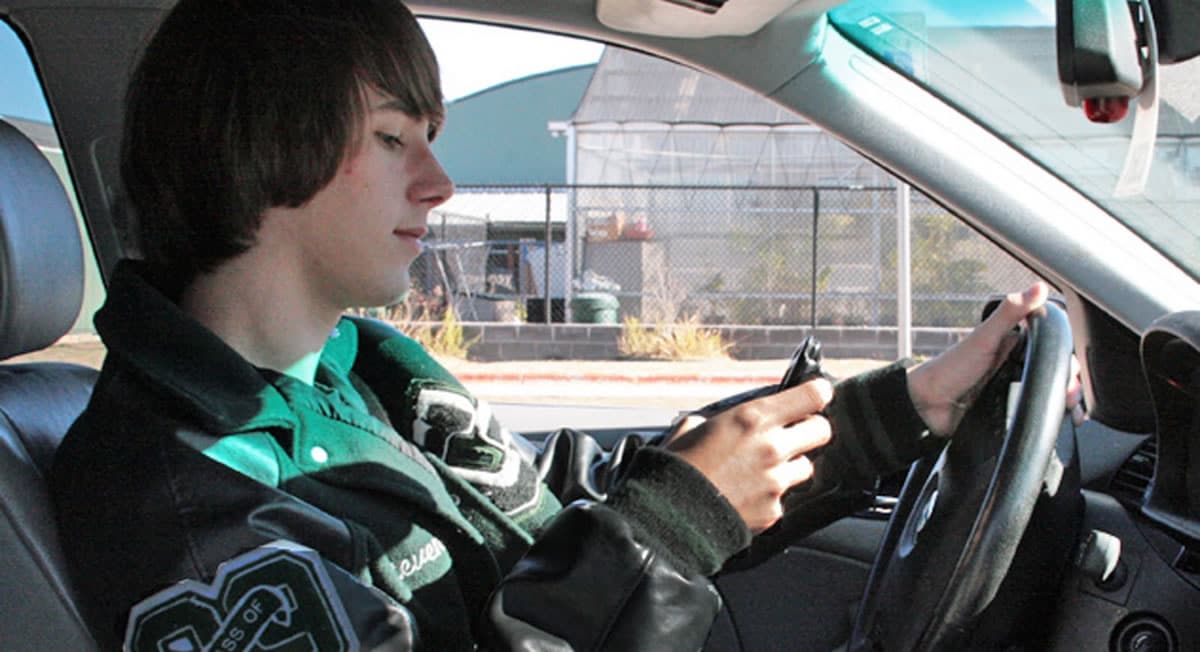 Joven manejando y usando telefono