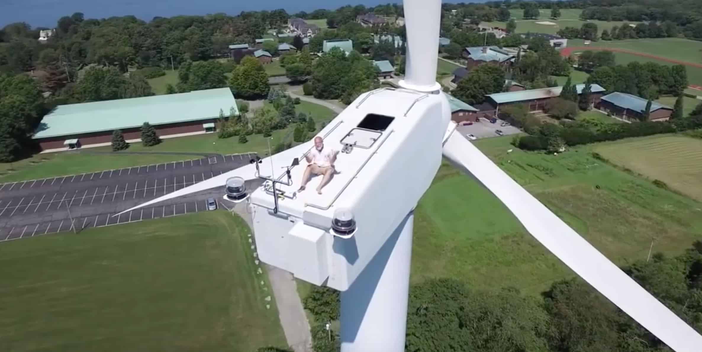 Drone sorprende a un hombre tomando sol arriba de una turbina eólica.